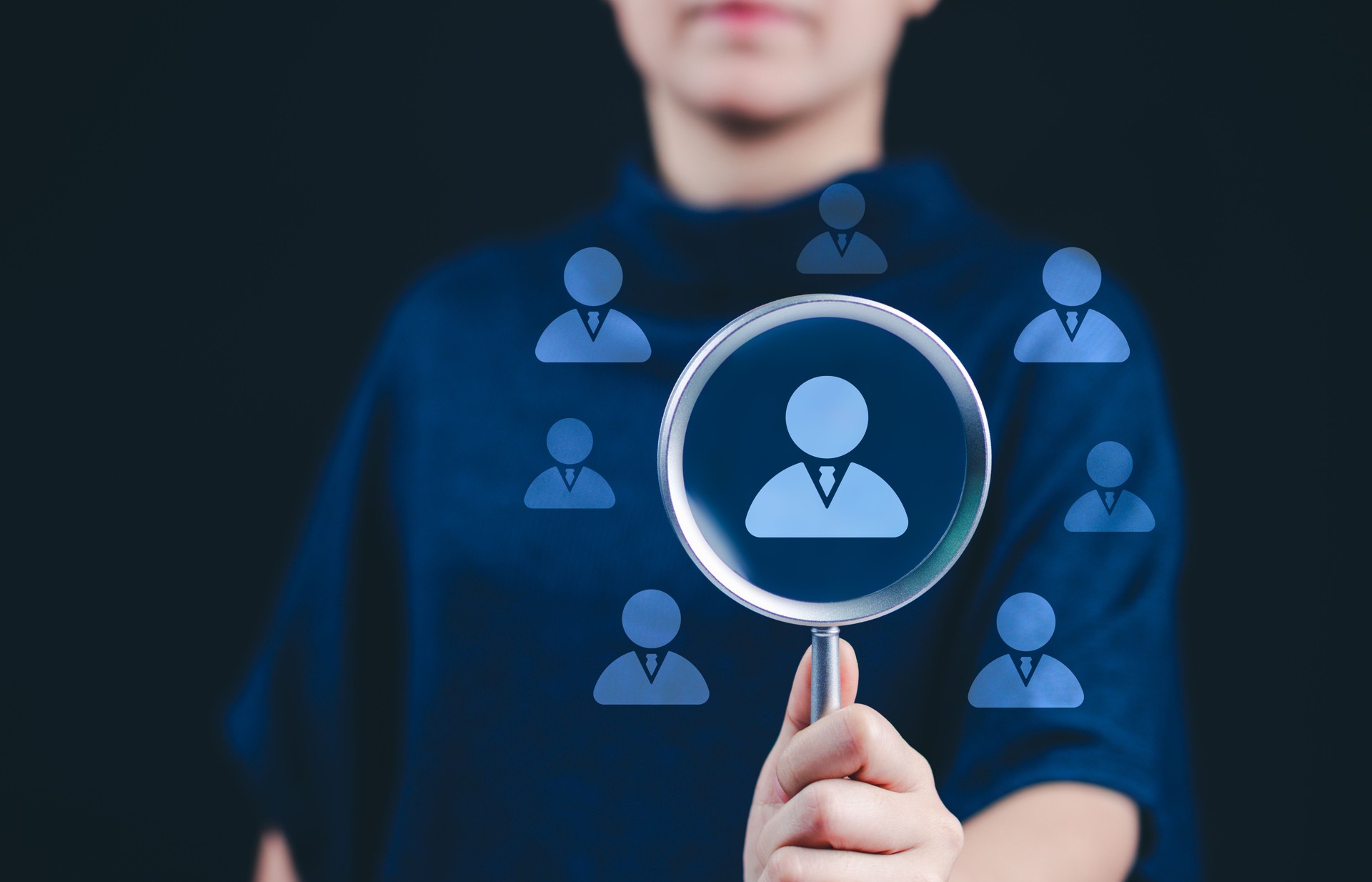 HR, Human Resources Selection and Recruitment Concept. HR professional holding magnifying glass focusing on candidate icon, symbolizing employee selection, recruitment, and human resource management.